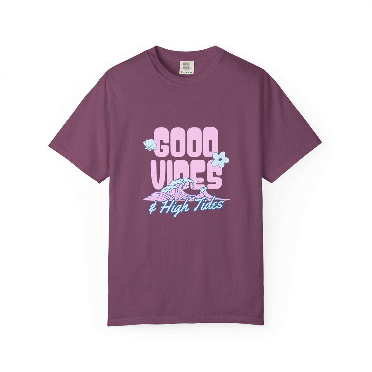 A short-sleeve crewneck t-shirt in a dusty plum purple color, featuring a retro-style graphic on the chest that reads 'GOOD VIBES & High Tides' in pink and light blue, accompanied by a pink and blue wave illustration and small light blue flowers.