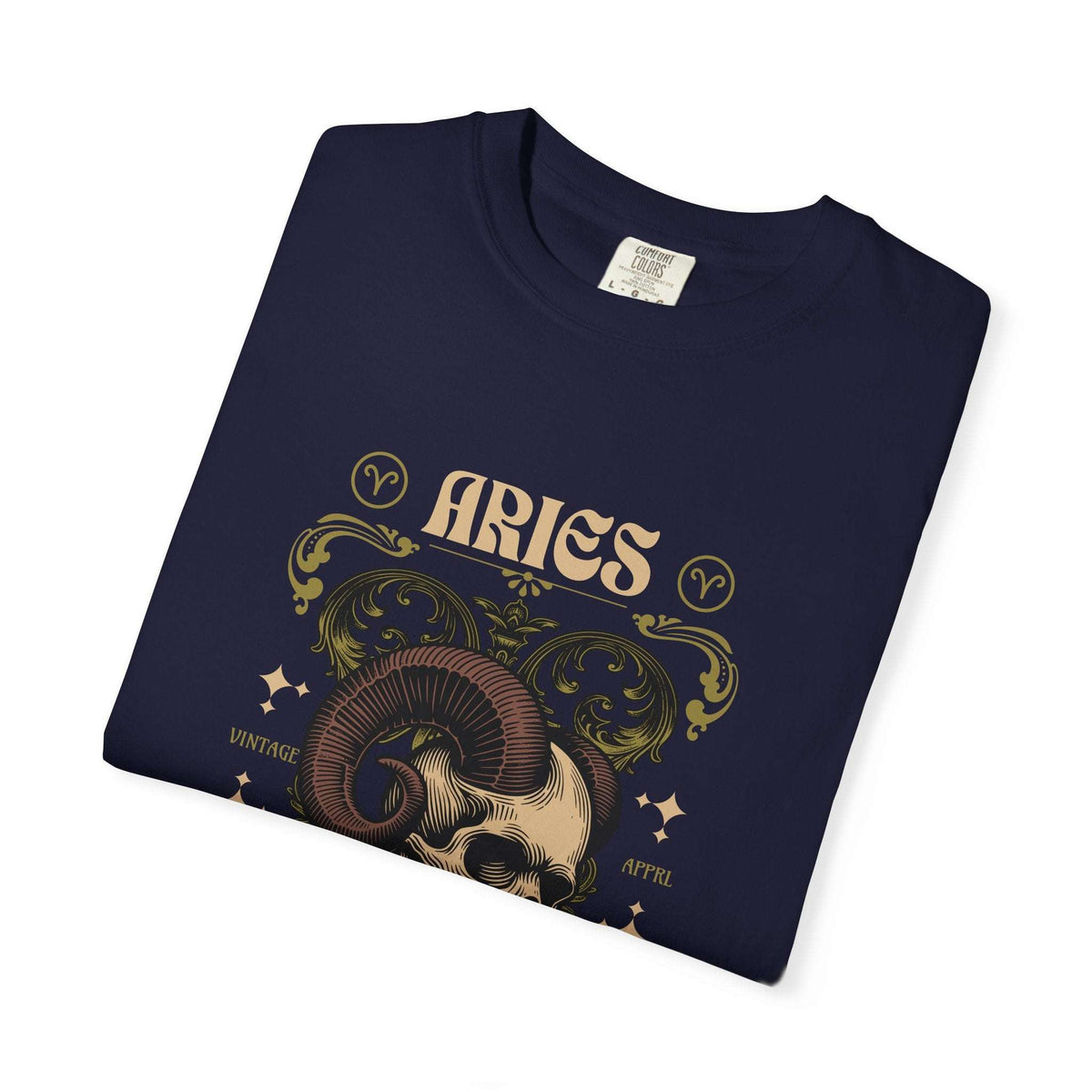 A folded black t-shirt with a vintage-style Aries zodiac graphic featuring a ram skull, ornate gold and beige scrollwork, and the word 'ARIES' on a white background.
